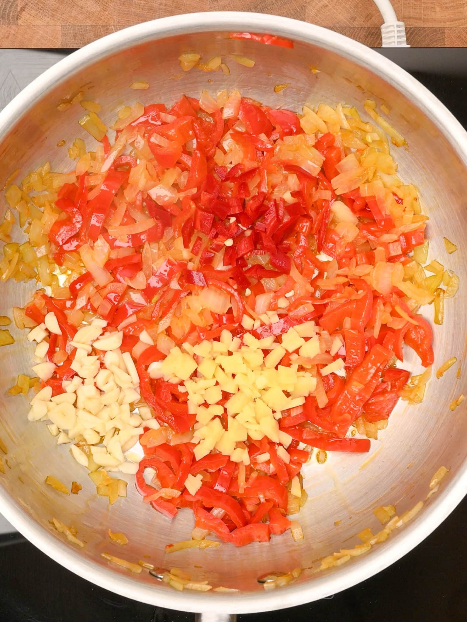 adding garlic and ginger to halloumi curry
