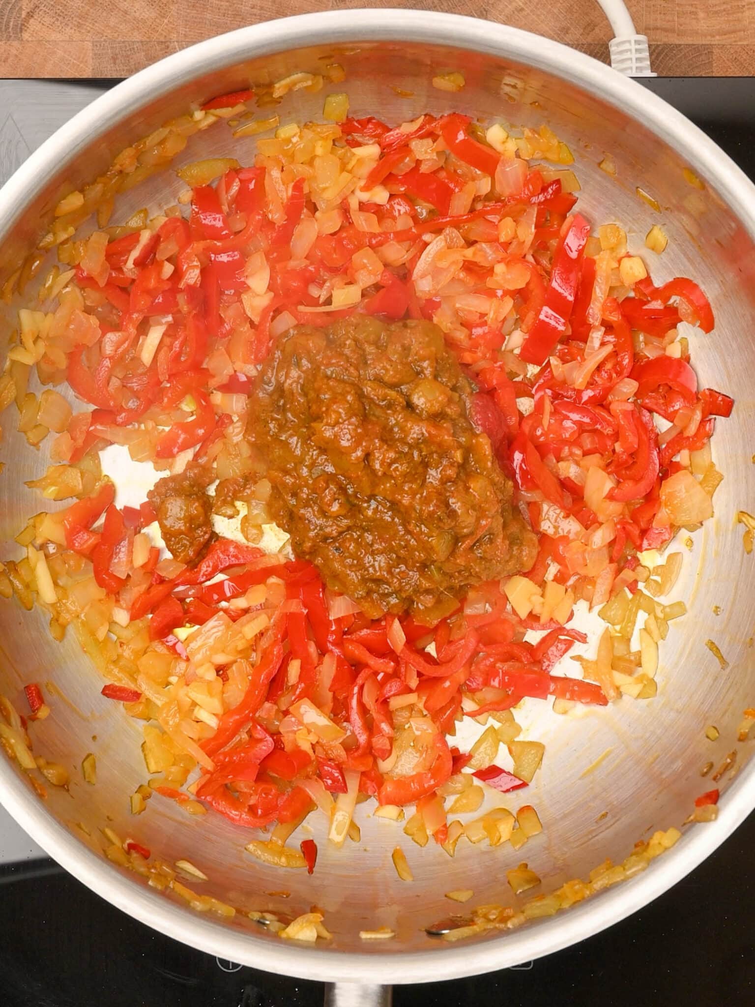 adding curry paste to the cooking pot