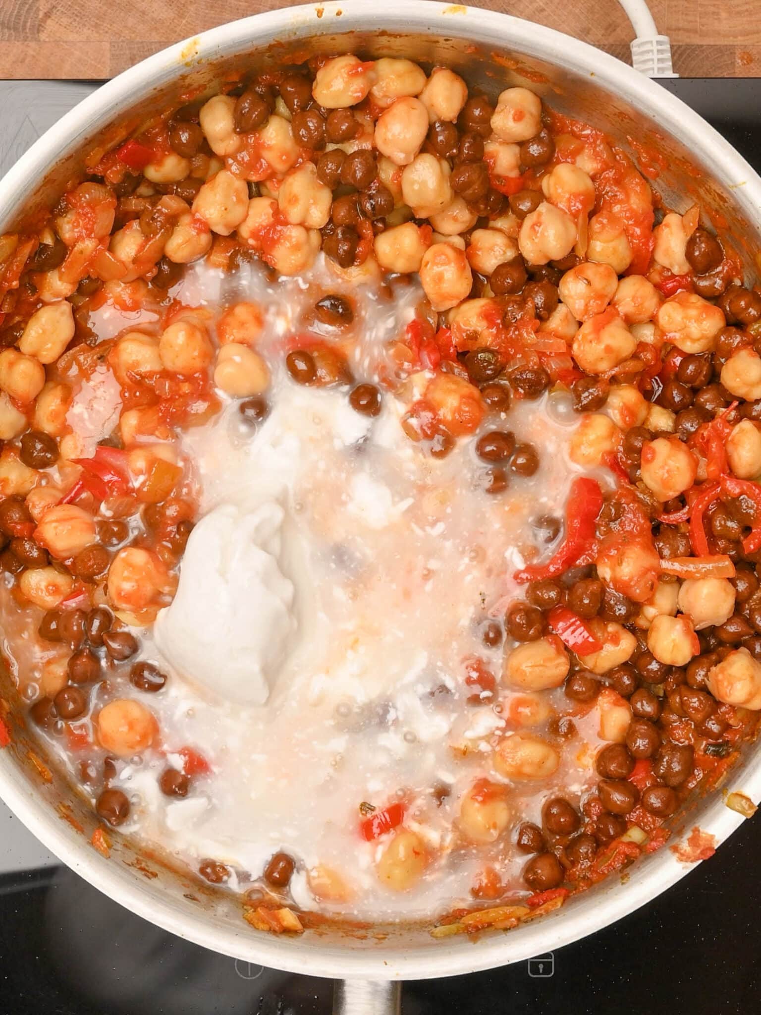 adding coconut milk to halloumi curry