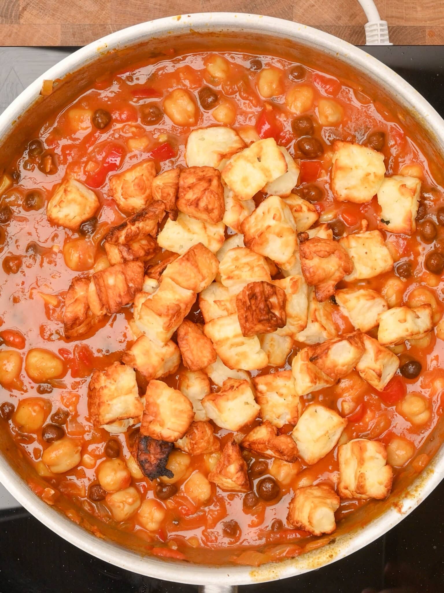 adding halloumi to the cooking pot