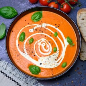black bowl of soup with basil on top