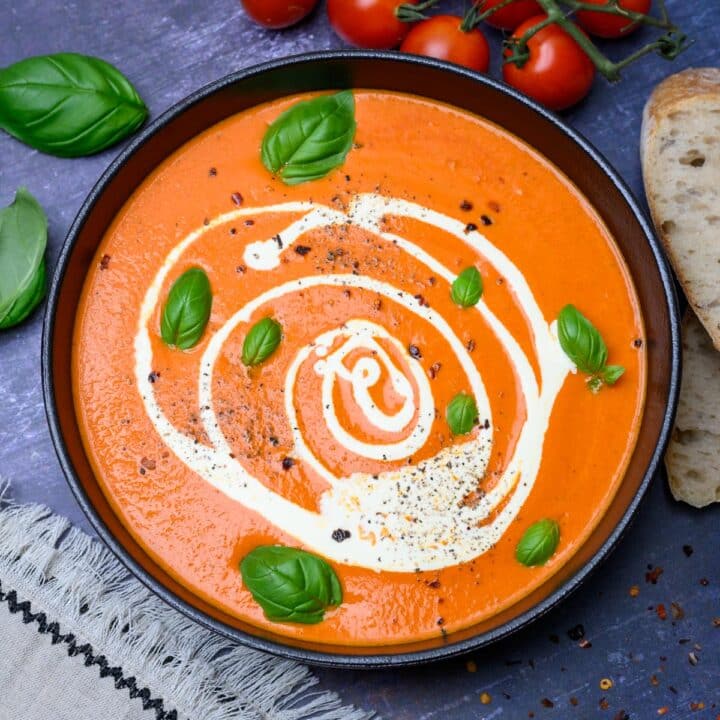 black bowl of soup with basil on top