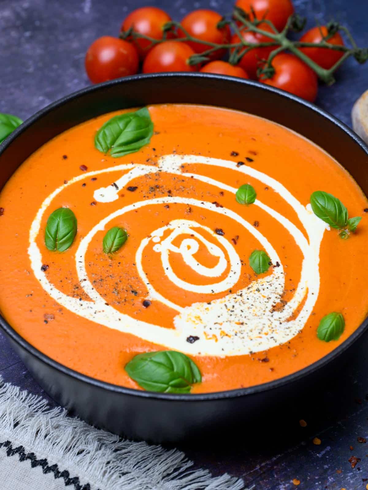 Close up photo of a bowl of roasted red pepper and tomato soup.