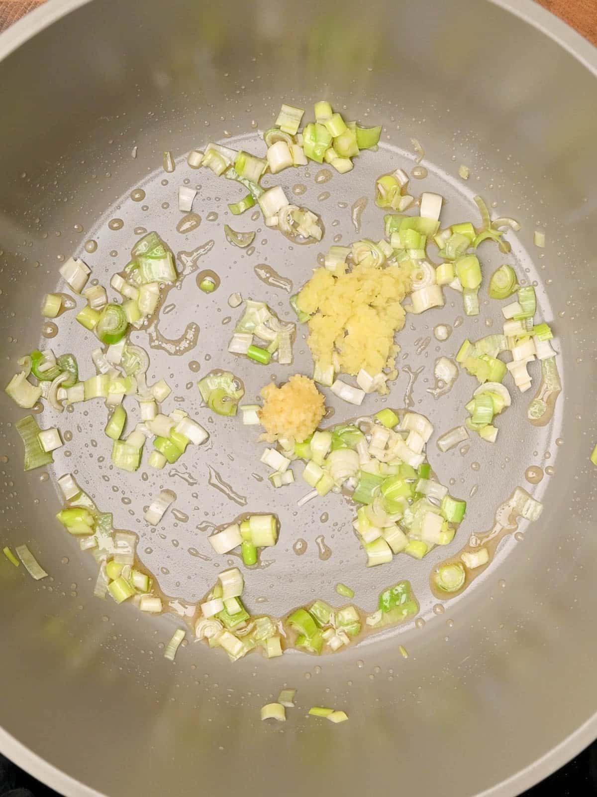 adding garlic and ginger to wonton soup