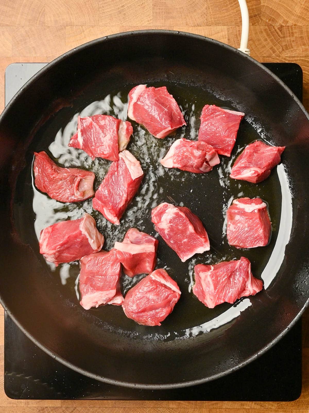 adding pieces of steak to an italian beef stew