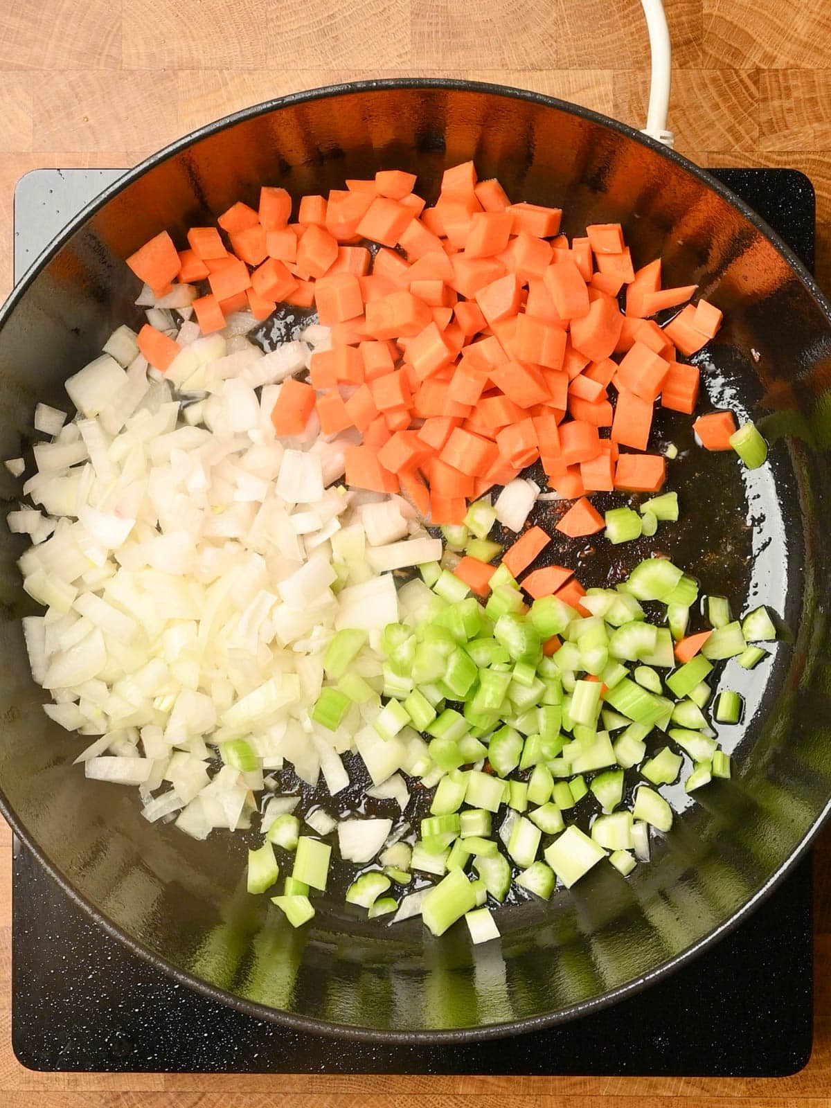adding carrots, onion and celery to an italian beef stew