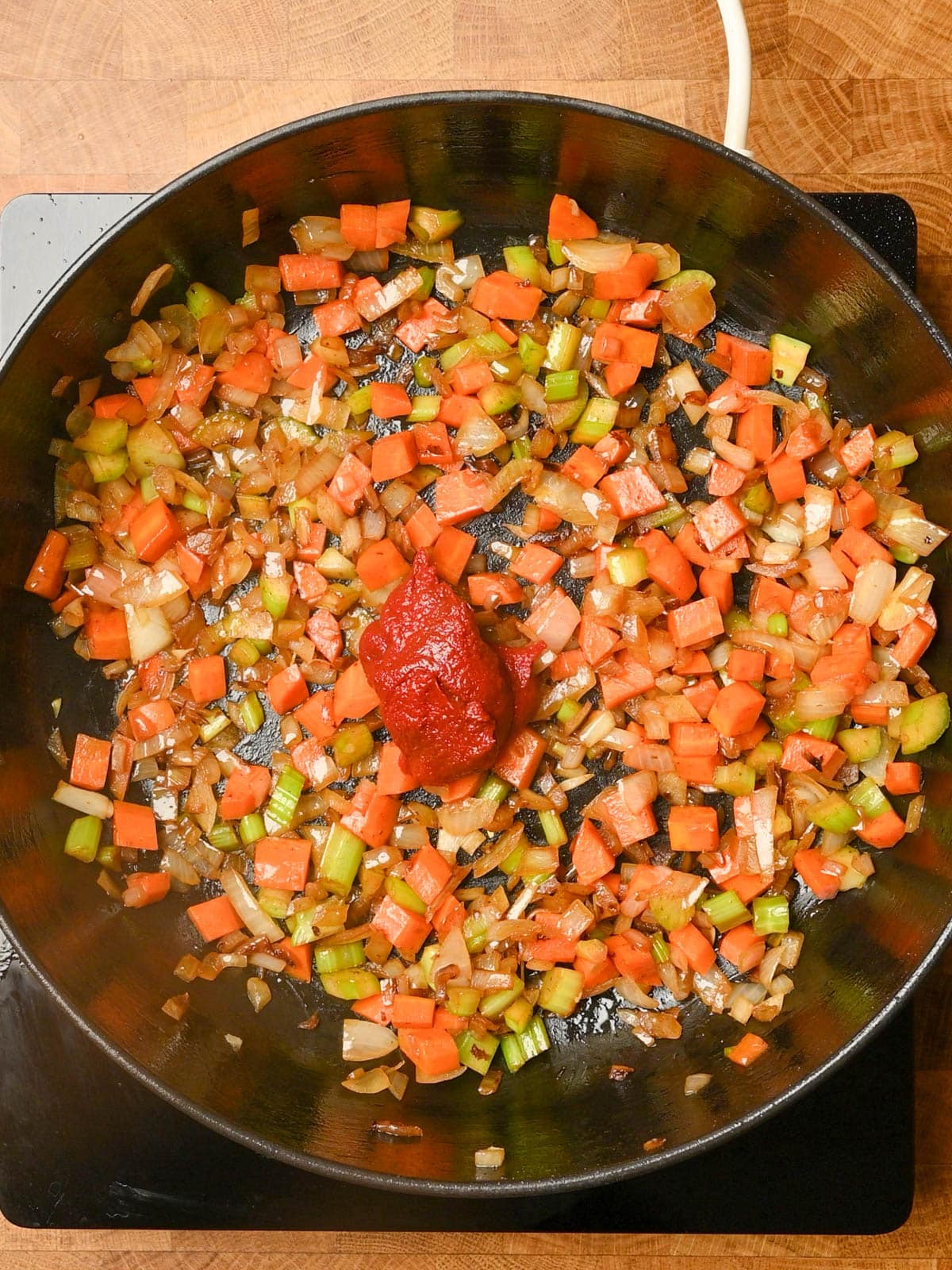 adding tomato paste to an italian beef stew