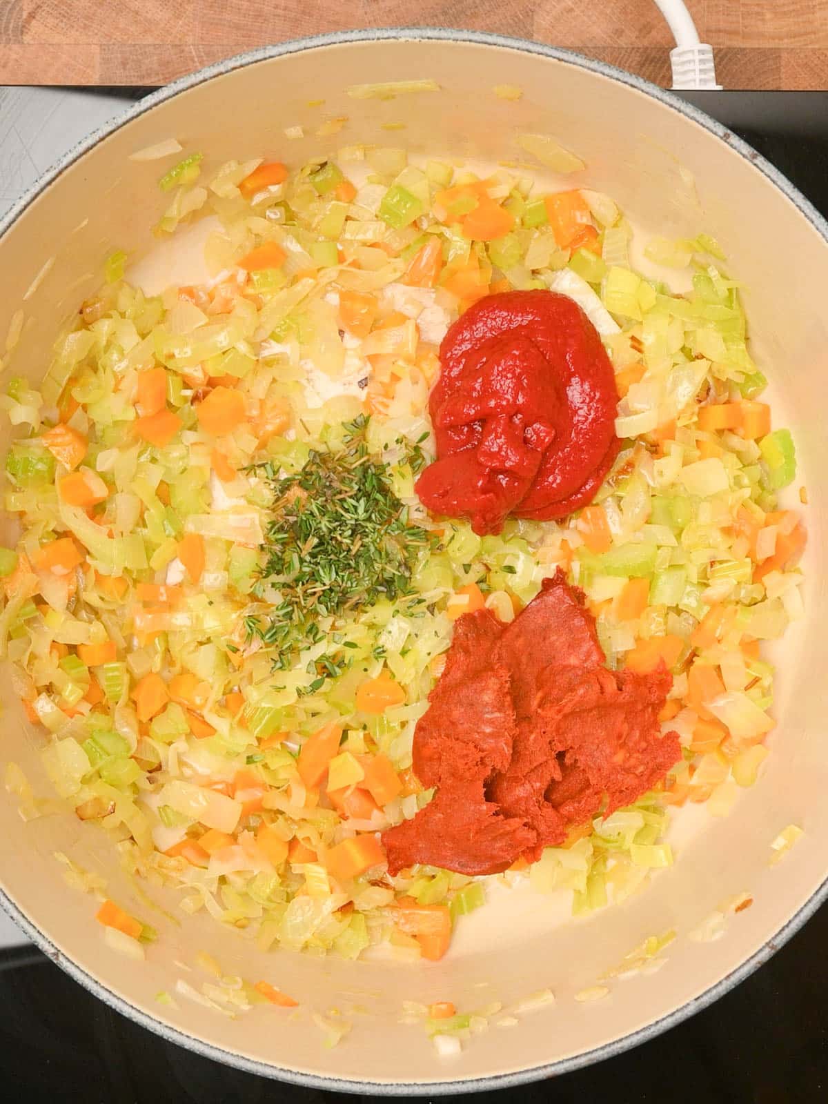 adding nduja, tomato paste and rosemary to the pot