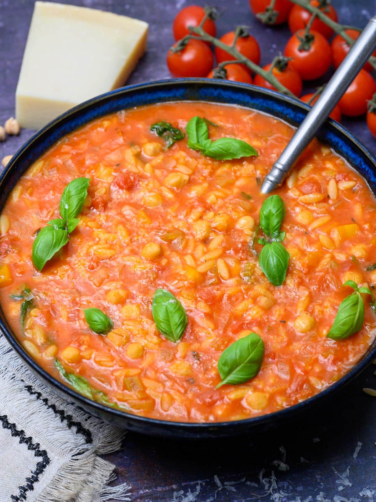 close up photo of a bowl of chickpeas with pasta and basil
